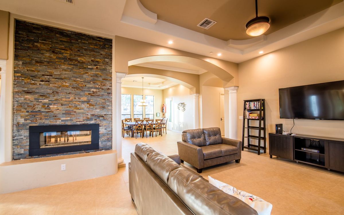 House One living room with fireplace, seating, and piano